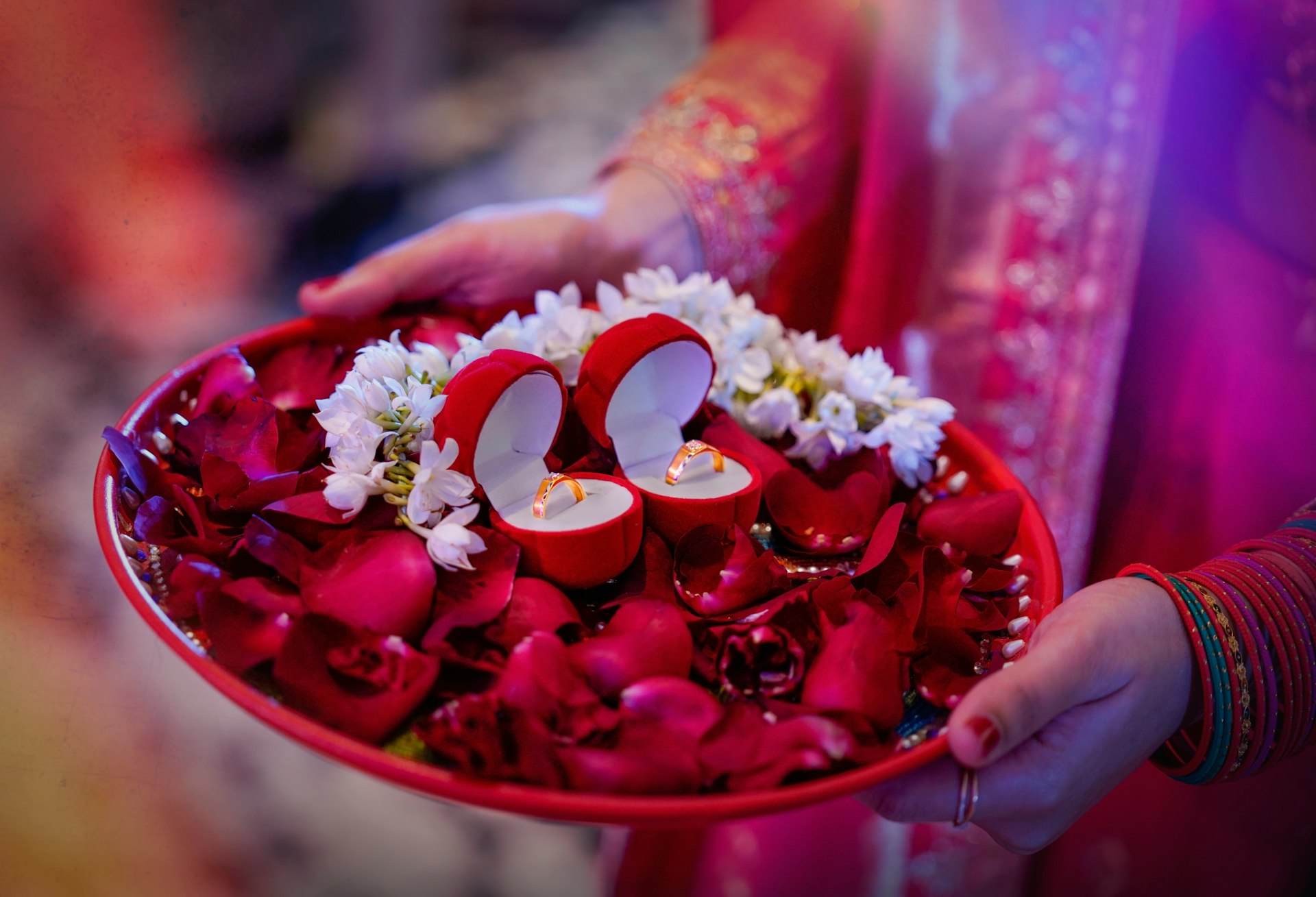 person holding red and white heart shaped ceramic bowl with white and red flowers